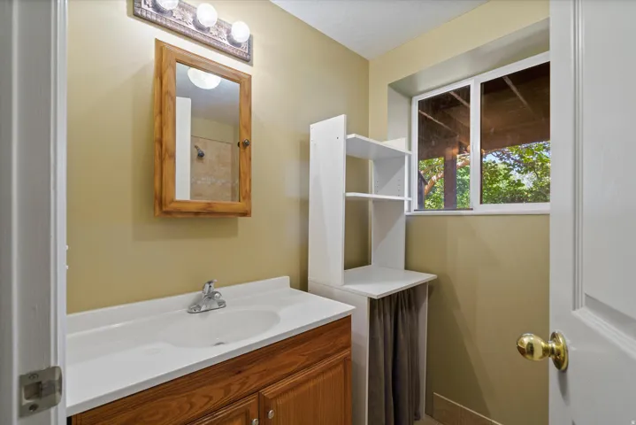 Wood-finish vanity with an integrated sink and chrome faucet