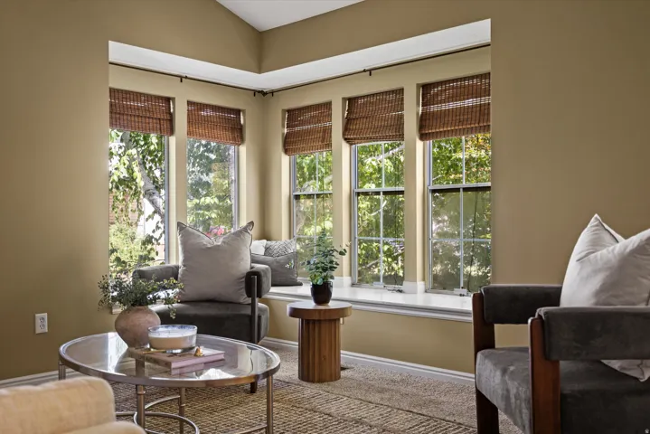 Bay window with a built-in window seat, multiple double-hung windows, and a vaulted ceiling