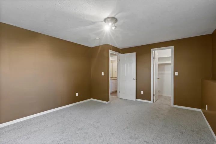 Wall-to-wall carpeting, recessed ceiling light fixture, white trim, and doors