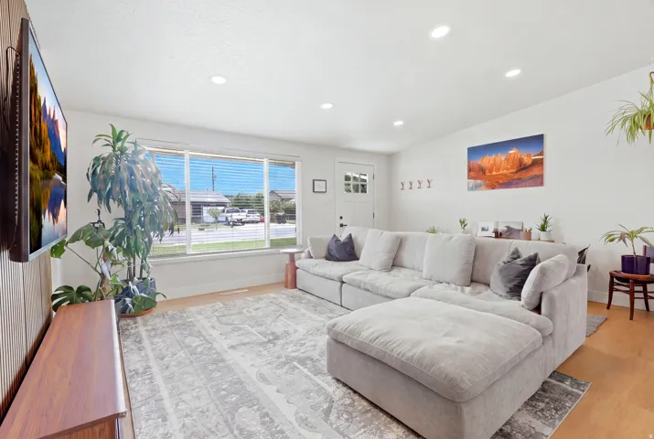 Wood-finish flooring, recessed ceiling lighting, and a front entry door with glass paneling