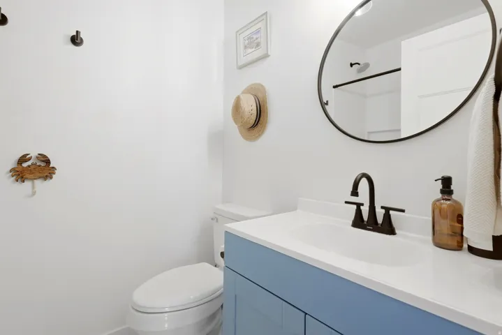 Vanity with a light blue finish, white countertop, and dark-toned faucet