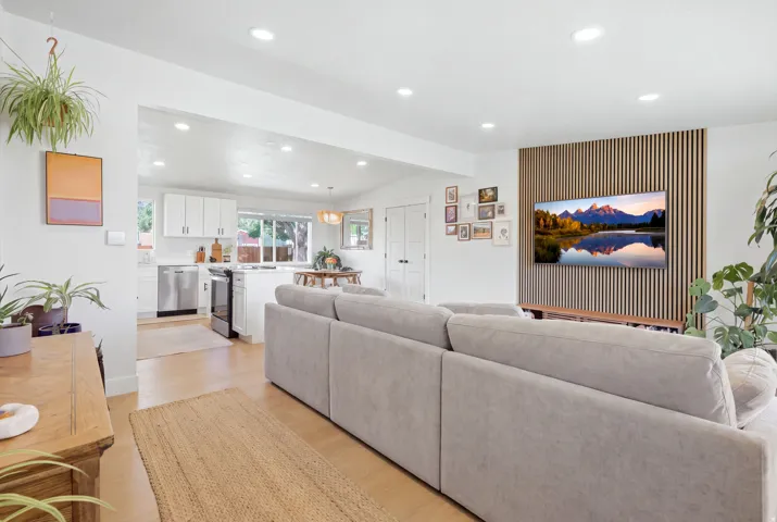 Recessed lighting, wood-finish flooring, and a decorative slatted wood accent wall
