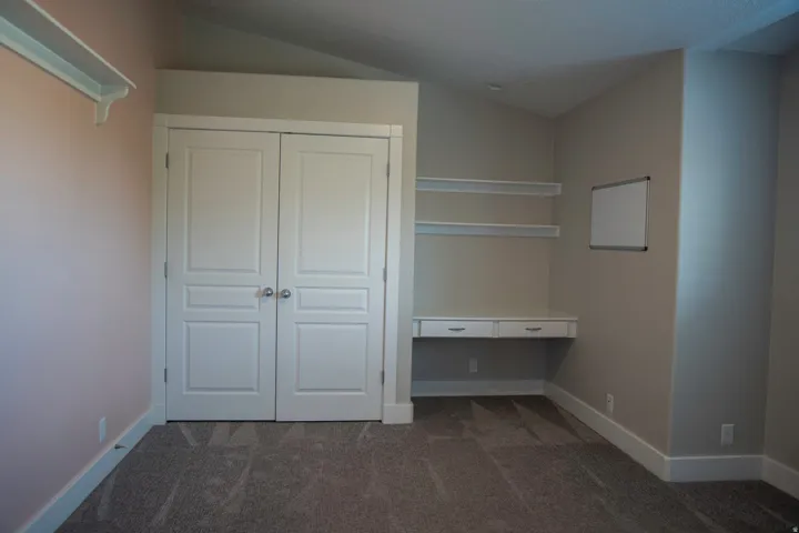 Built-in desk with dual drawers, integrated shelving, and a double-door closet