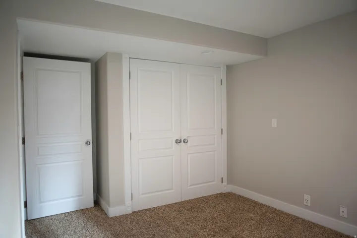 Neutral wall paint, plush carpet flooring, recessed ceiling lighting, and panel interior doors