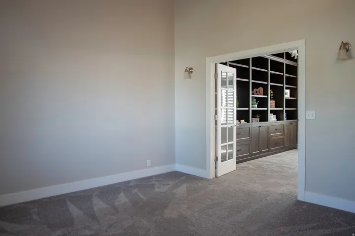 French doors opening to dining room with built-in shelving and cabinetry