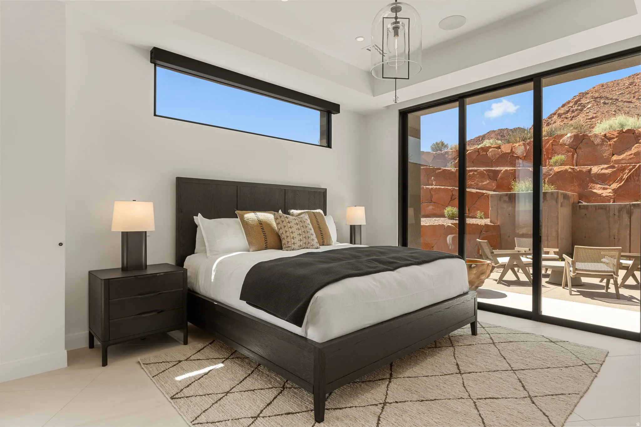 Expansive sliding glass doors, upper transom window, built-in ceiling speaker, recessed lighting, and a contemporary ceiling fixture