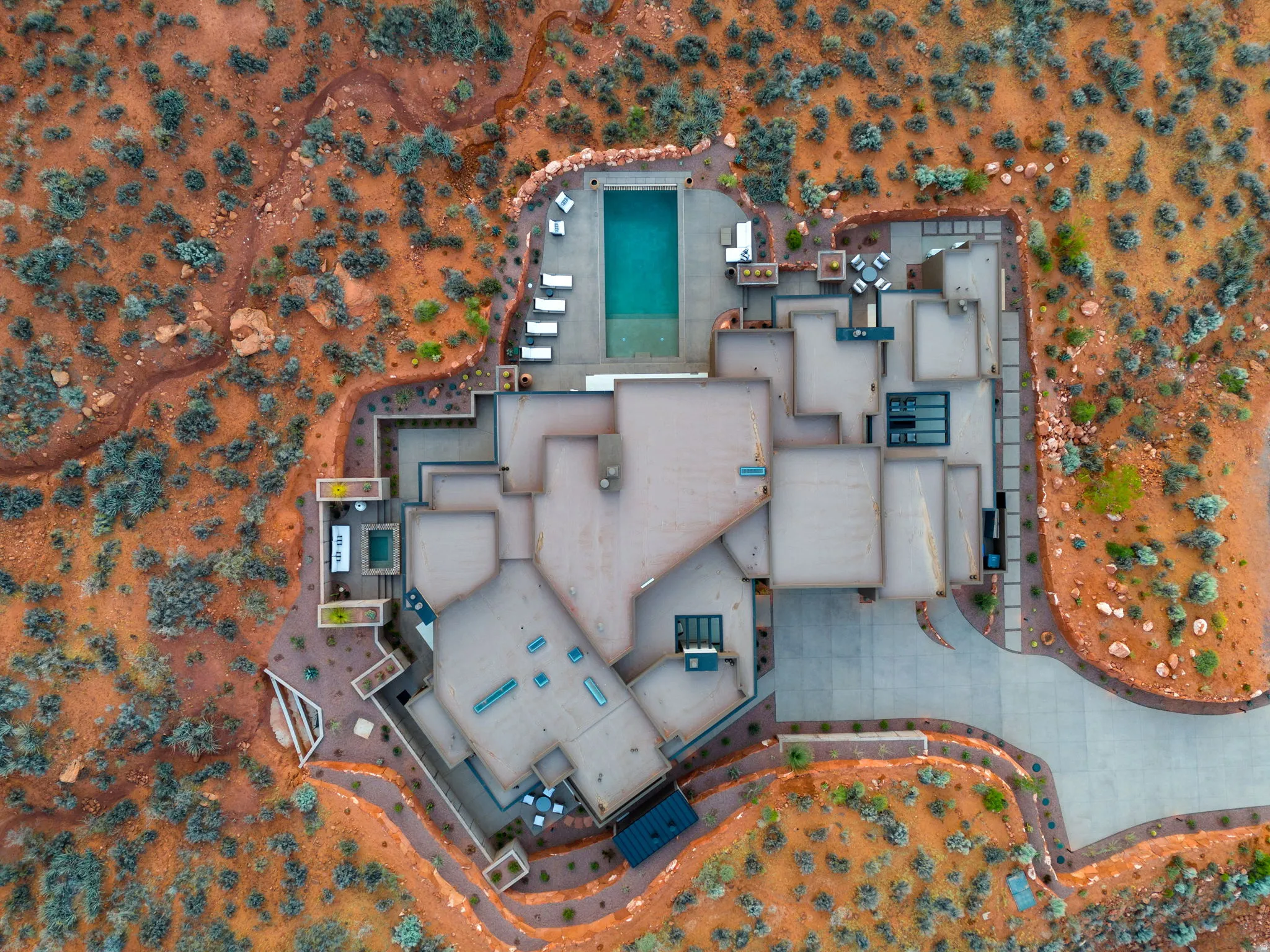 Expansive property featuring an outdoor swimming pool, integrated spa, multiple patio areas, and a concrete driveway