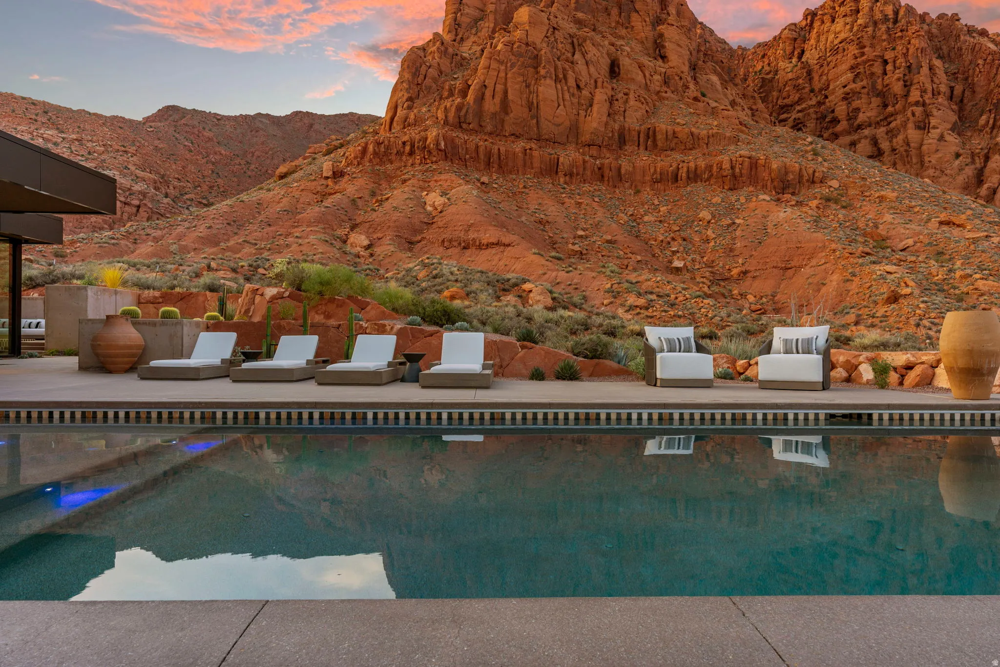 Expansive outdoor pool with a surrounding concrete patio and desert landscaping