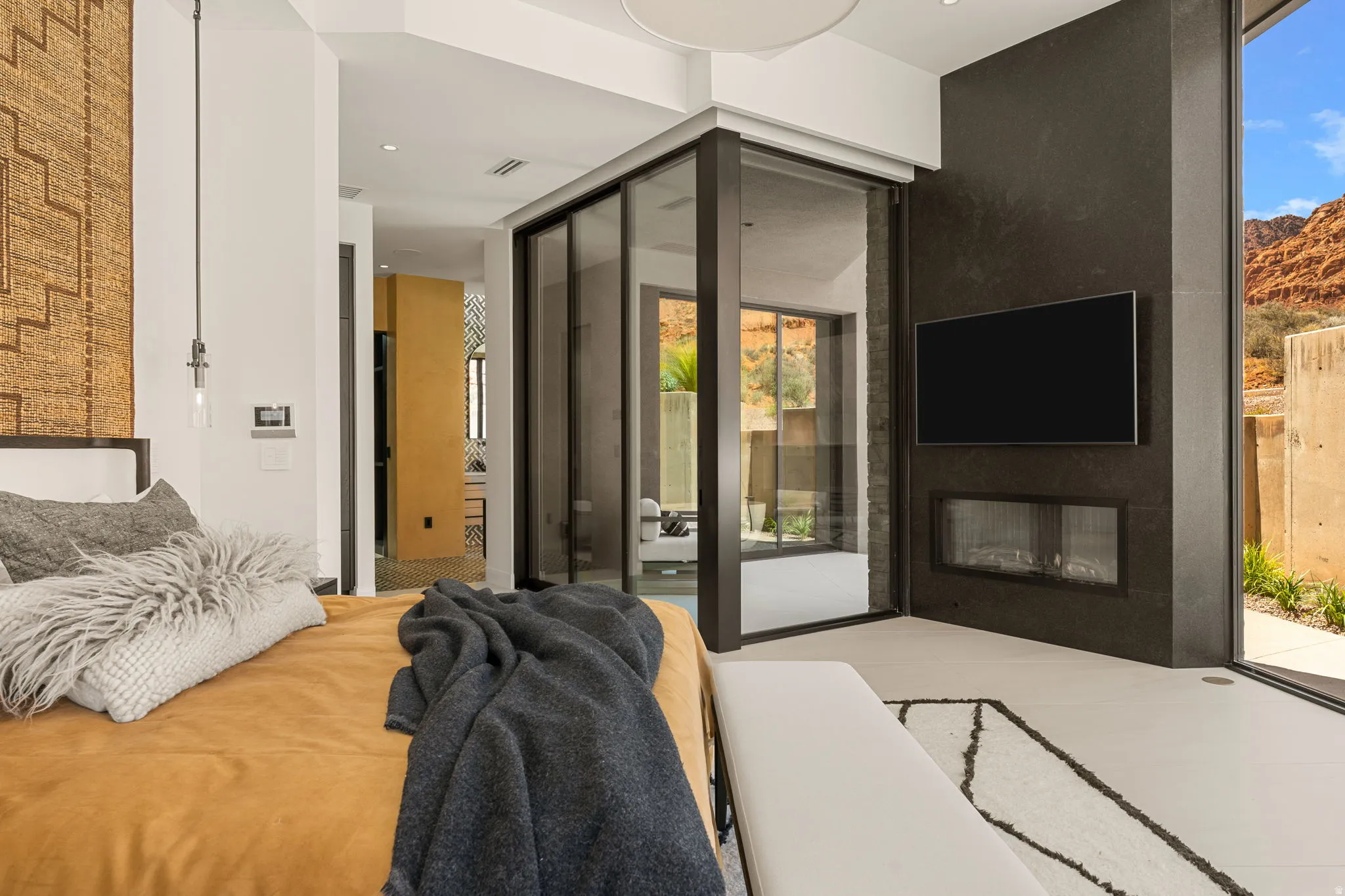 Built-in fireplace with a linear firebox, large format wall-mounted television, and expansive sliding glass doors