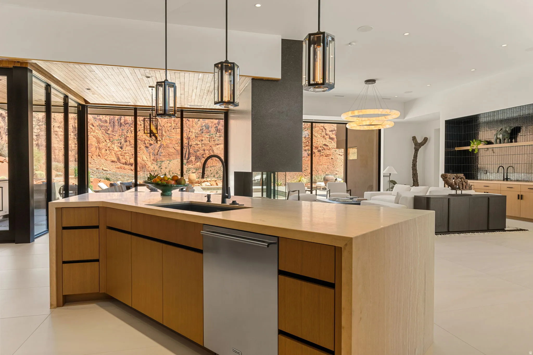 Expansive kitchen island with wood-finish cabinetry, integrated sink, and stainless steel dishwasher