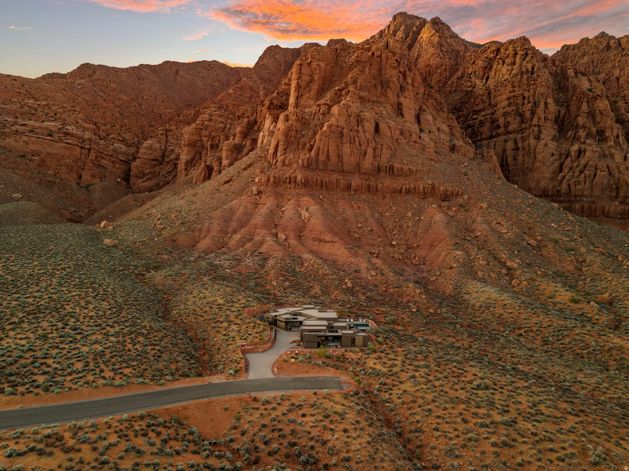 Mountain property featuring an extensive natural landscape, a winding paved driveway, and a modern architectural design