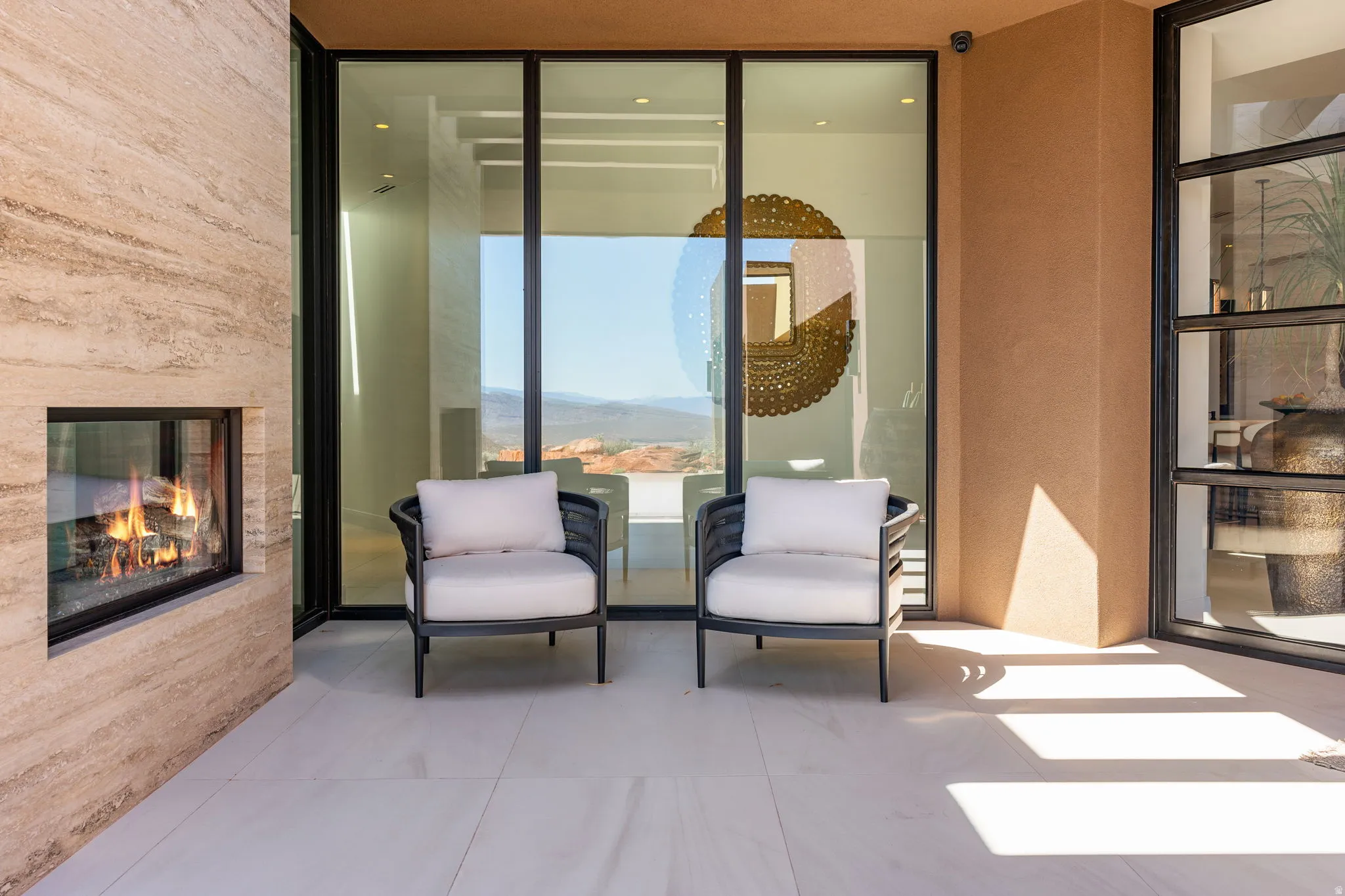 Outdoor patio with a stone-clad fireplace and large format tile flooring