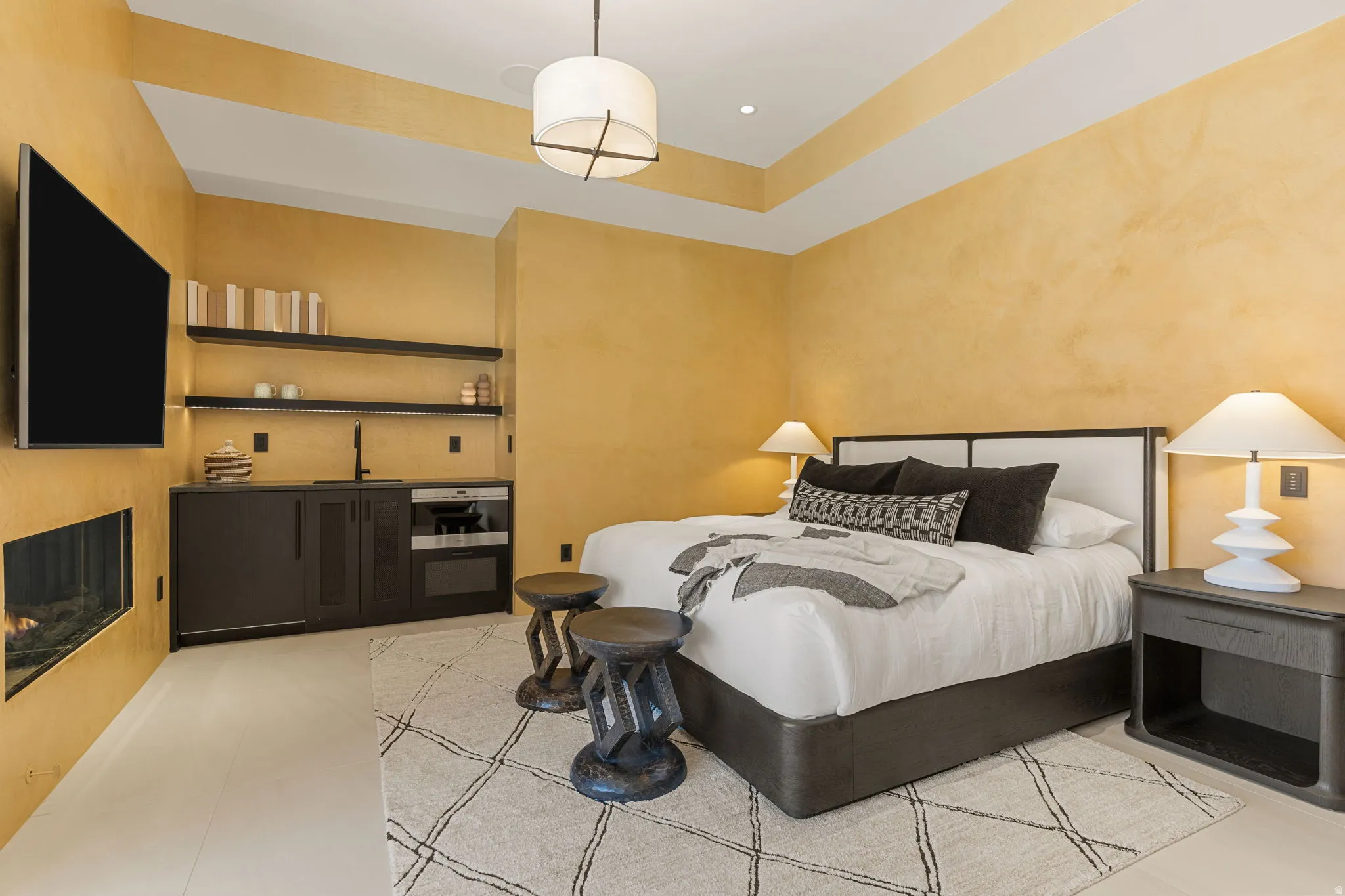 Room featuring a built-in fireplace, tray ceiling, and light wood-finish flooring