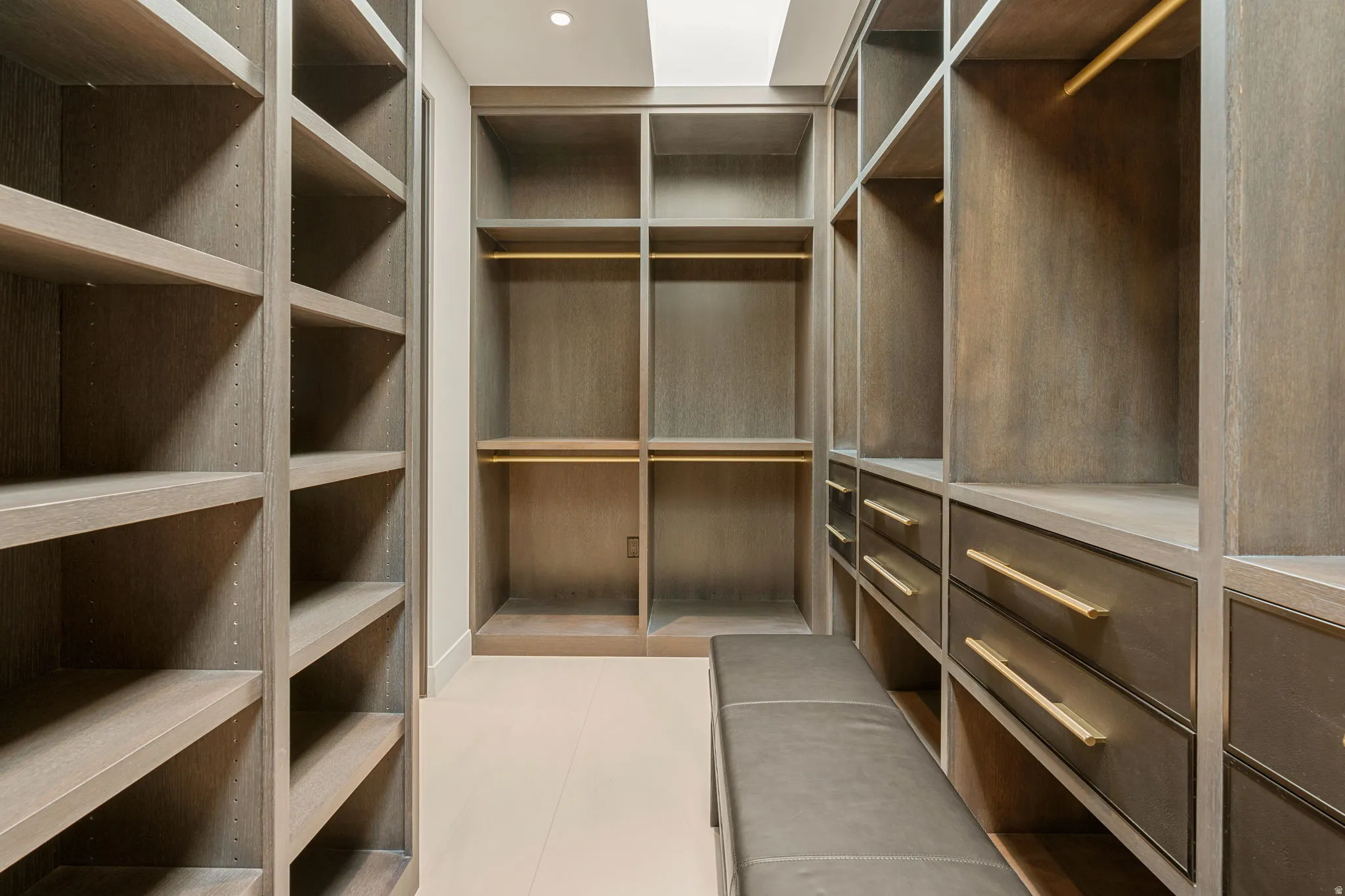 Custom built-in shelving with integrated drawers, wood-finish construction, and recessed lighting