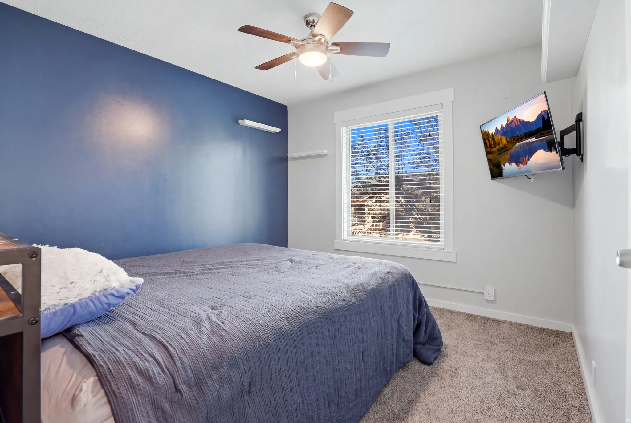 Recessed window with white trim, wall-mounted light fixture, ceiling fan with light, and carpeted flooring