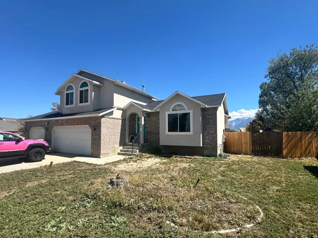 Two-story exterior with brick and stucco accents, arched entry, and dual garage doors