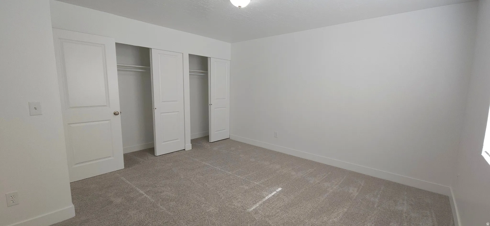 Neutral wall tones, recessed lighting, and carpeted flooring