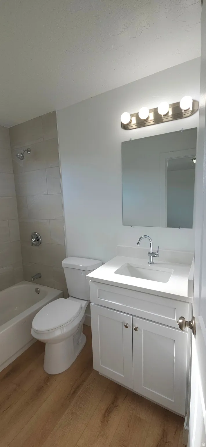 White vanity with integrated sink, chrome faucet, and rectangular mirror