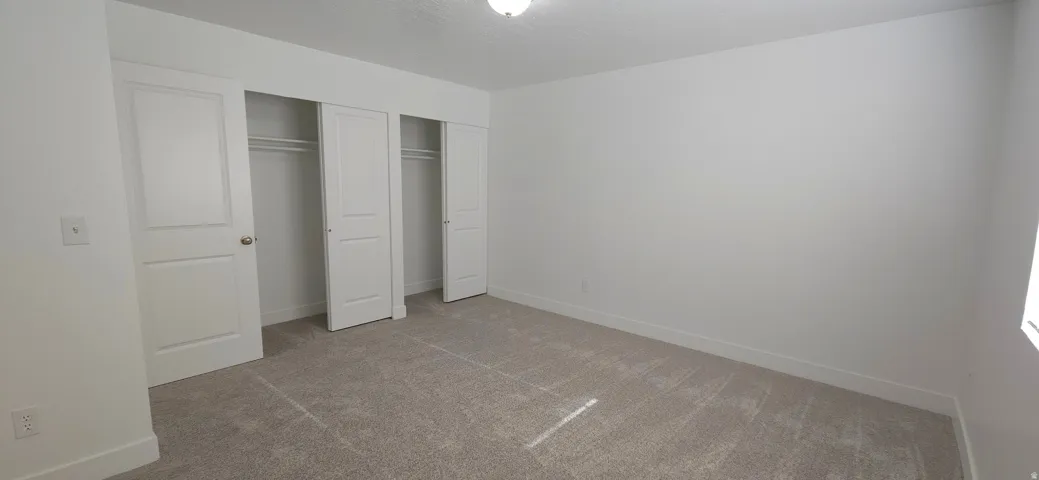 Neutral wall tones, recessed lighting, and carpeted flooring