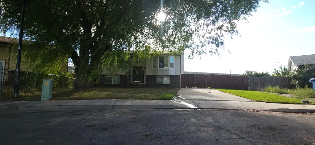 Split-level residence featuring a bay window, concrete driveway, and established front landscaping