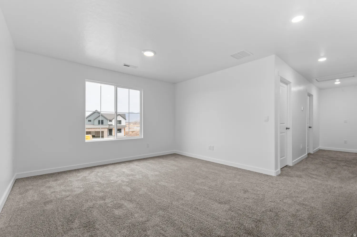 Recessed ceiling lighting, white interior doors, and neutral carpeting