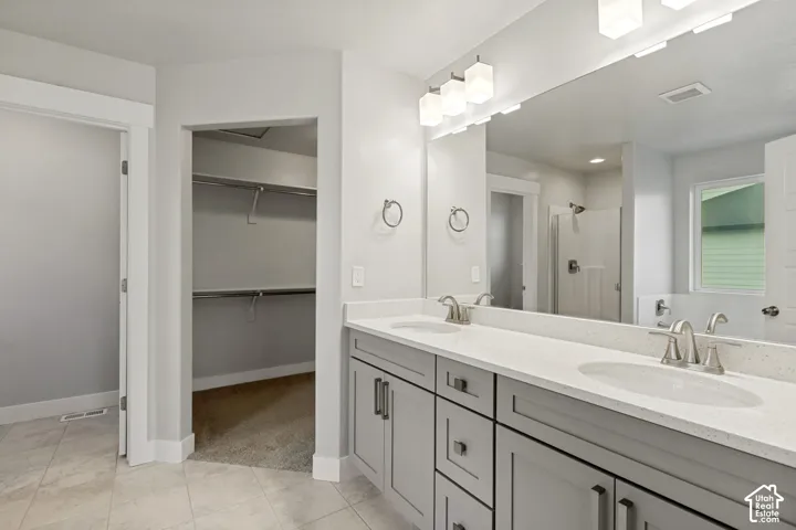 Dual vanity with light gray cabinetry, light-toned countertops, and undermount sinks
