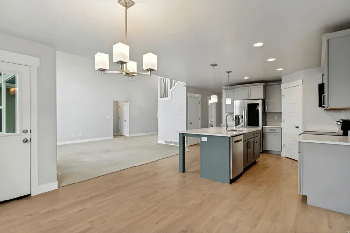 Open-concept kitchen and living area with wood-finish flooring, recessed lighting, and a kitchen island with pendant lighting
