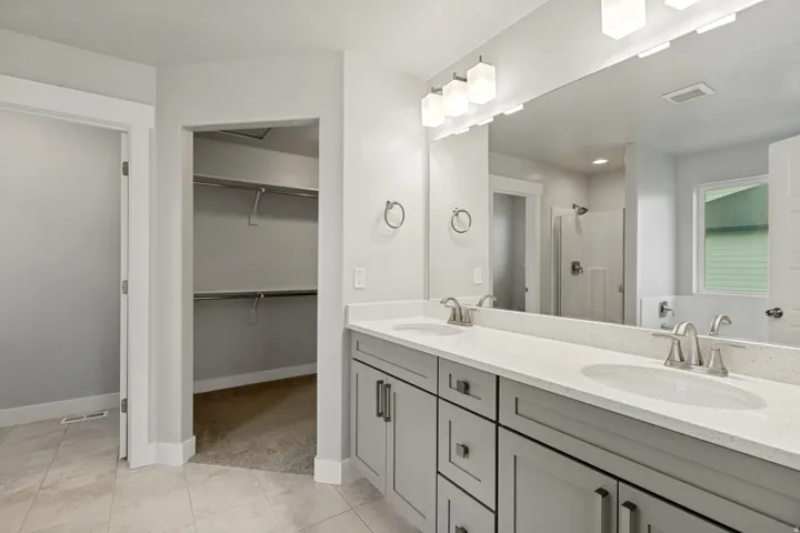 Dual vanity with light gray cabinetry, light-toned countertops, and undermount sinks