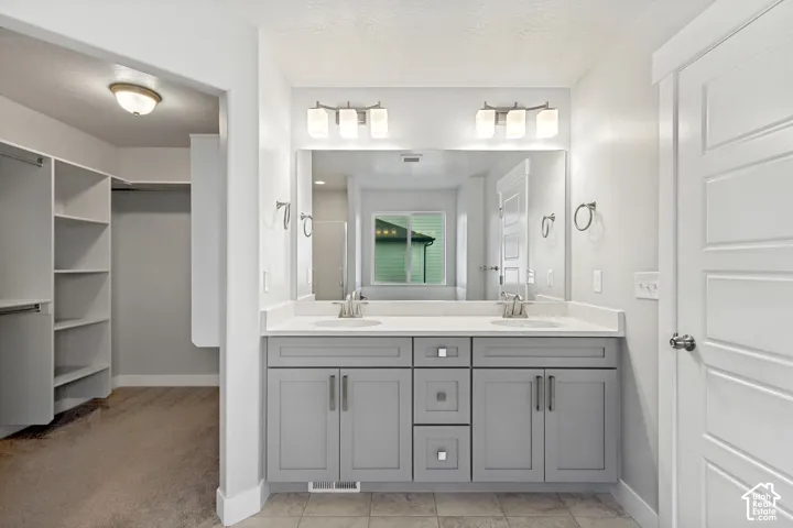 Dual vanity with light gray cabinetry, integrated sinks, and polished chrome fixtures
