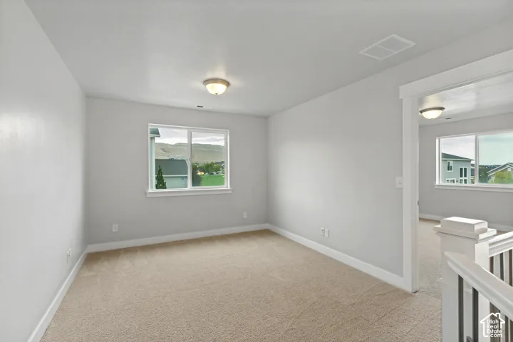 Carpeted room with white trim, a single window, and an overhead light fixture