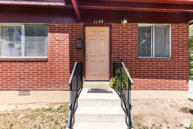 Brick exterior with concrete steps and wrought iron railings