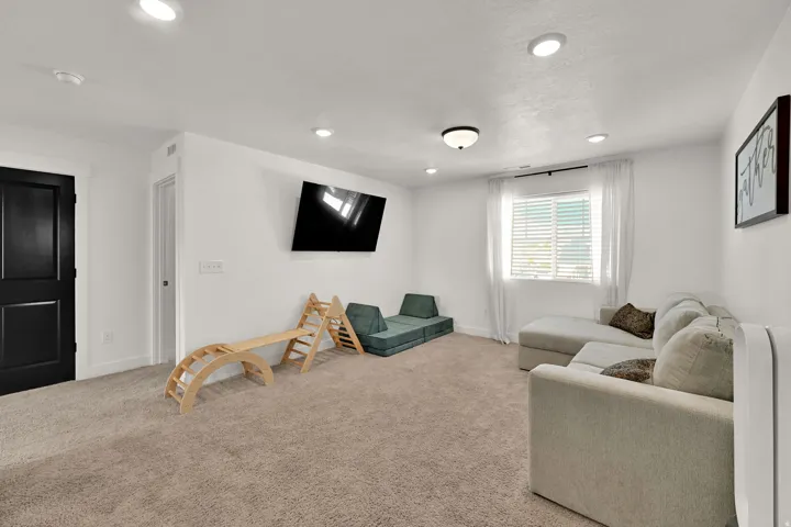 Recessed lighting, window with blinds, and mounted television