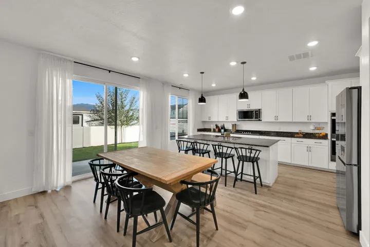 Contemporary kitchen with white cabinetry, dark countertops, and stainless steel appliances
