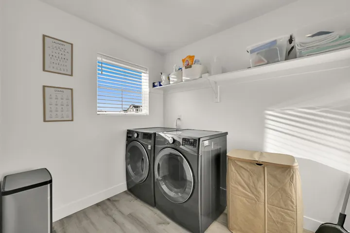 Dedicated laundry area featuring a window, wood-finish flooring, and a built-in wall shelf