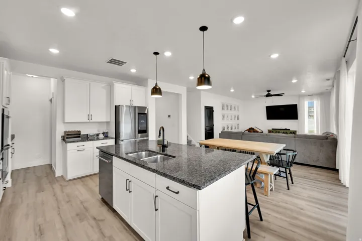 Kitchen island featuring a double-basin stainless steel sink and dark countertop