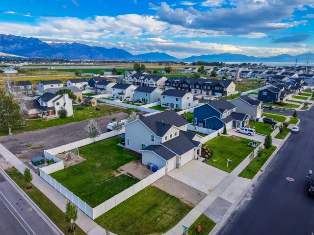 Residential neighborhood with contemporary homes, featuring a prominent mountain backdrop and a large body of water