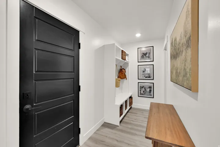 Built-in storage bench, recessed lighting, and wood-finish flooring