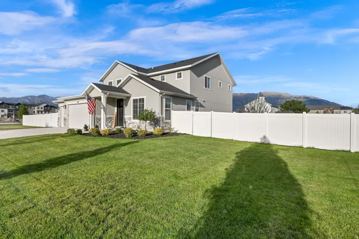 Contemporary two-story exterior with an attached two-car garage, covered entry, and a white privacy fence