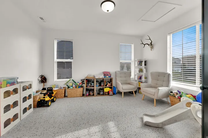 Recessed lighting, multiple windows with blinds, light-toned walls, and grey patterned carpet