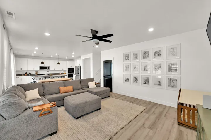 Open concept living space with wood-finish flooring, recessed lighting, and a ceiling fan
