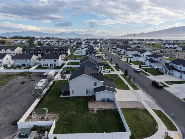 Expansive community with modern homes, paved streets, and a mountainous backdrop