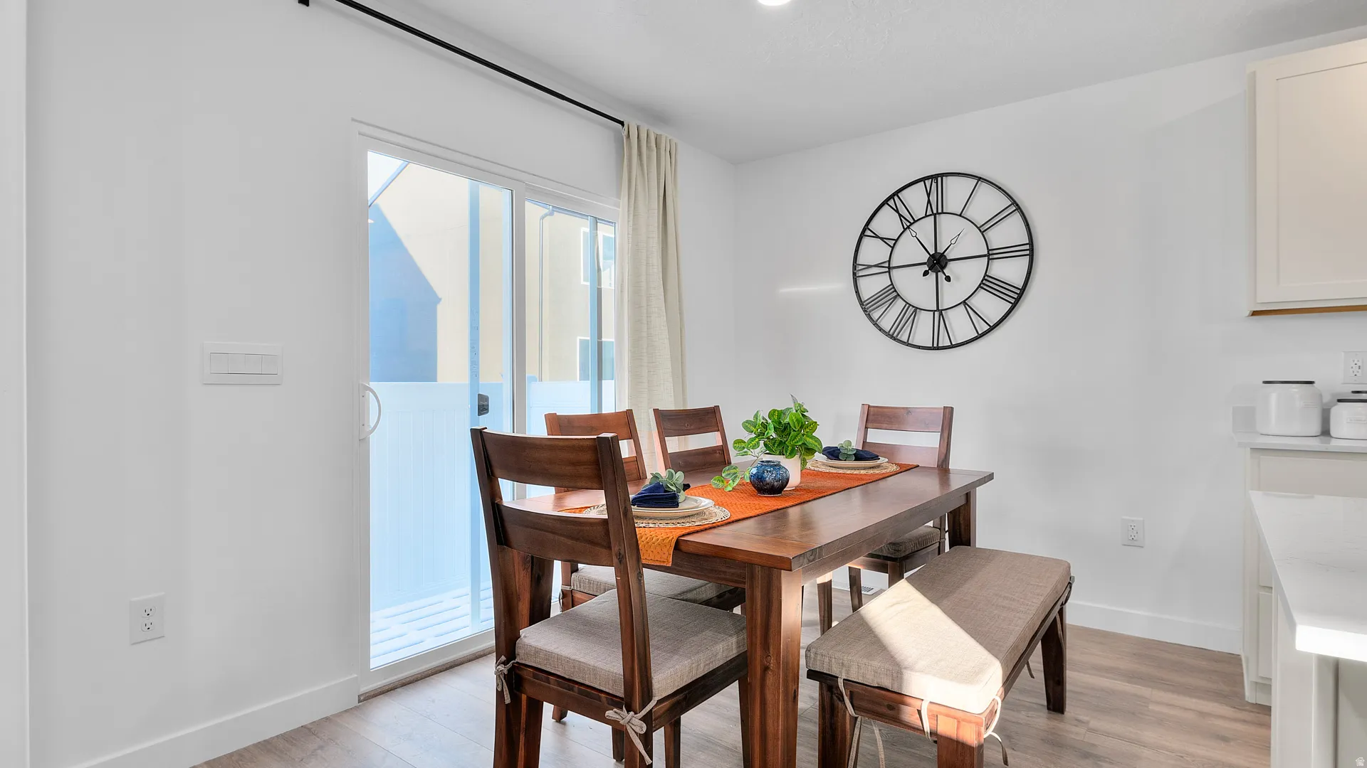 Wood-finish flooring, white walls, recessed lighting, and a sliding glass door with a privacy film