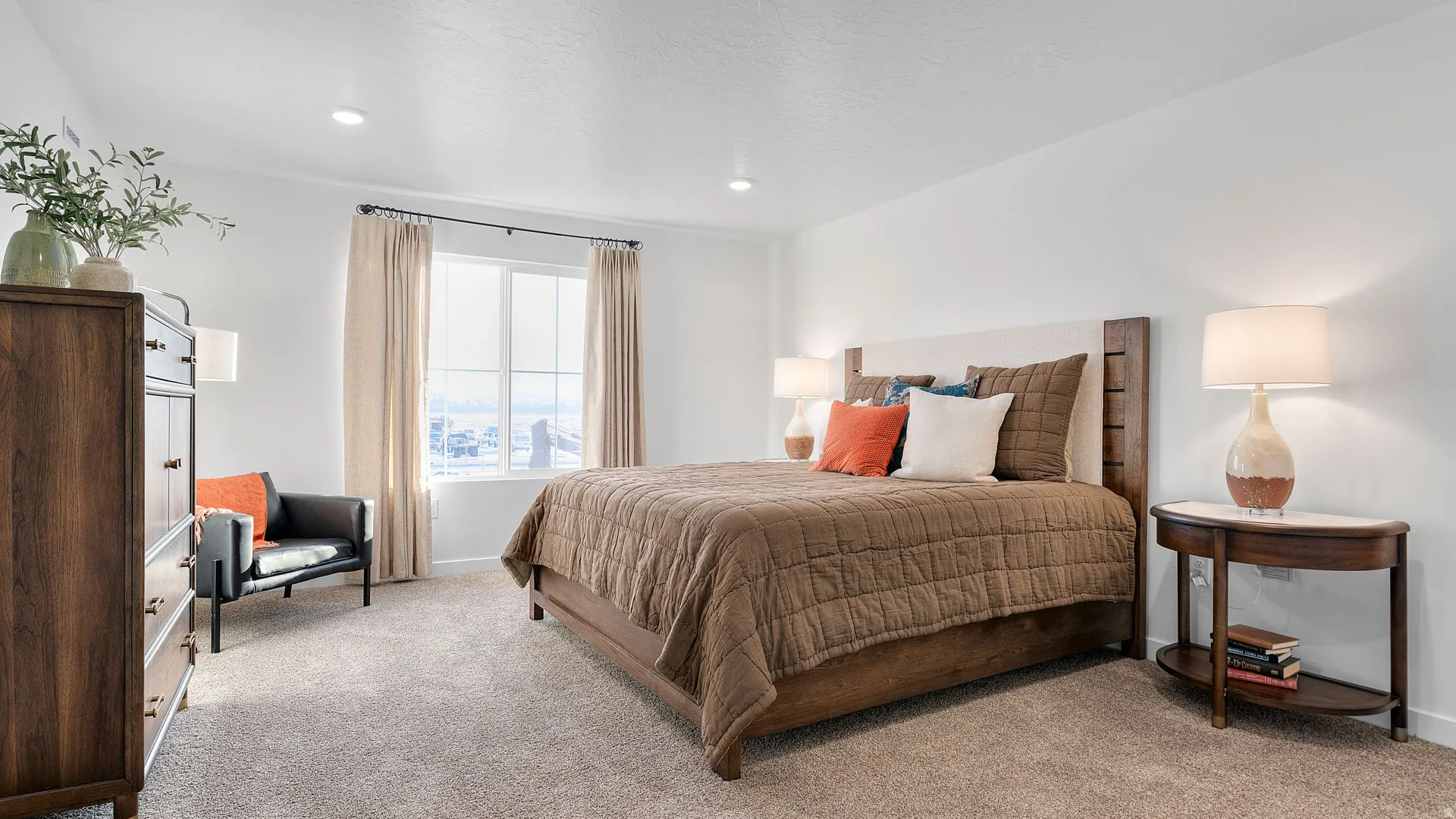 Recessed lighting, large window with natural light, neutral wall colors, and light-colored carpeting