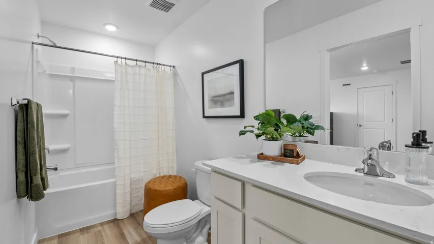 Bathroom featuring a vanity with an integrated sink, polished chrome faucet, and a large wall-mounted mirror