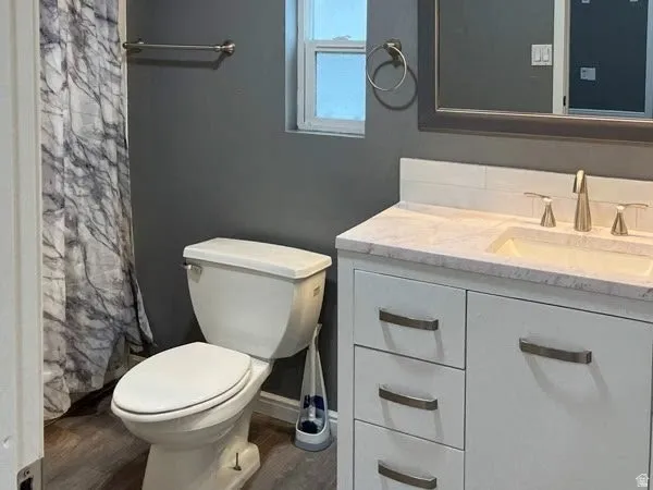 Full Bathroom in Master Suite, White vanity with brushed nickel hardware, light-toned countertop with integrated sink, brushed nickel faucet, and wood-finish flooring