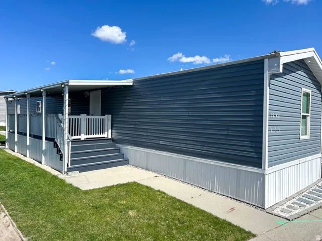 Covered front porch with white railings and blue siding exterior
