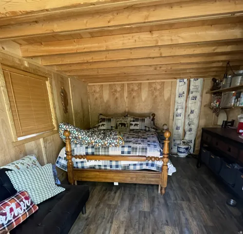 Wood-finish flooring with exposed ceiling beams and paneled walls