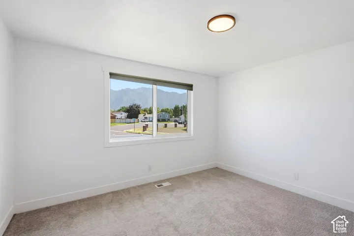 Neutral paint palette, natural light, carpet flooring, flush mount ceiling fixture, mountain scenery