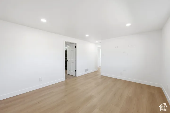 Recessed ceiling lighting, light wood-finish flooring, white painted walls, and white trim