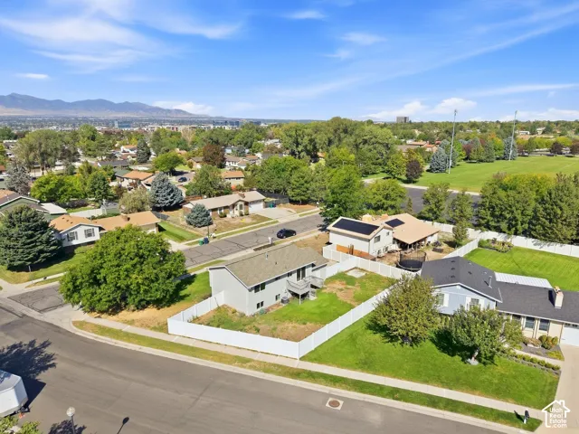 Residential property with a spacious backyard, white privacy fencing, and mature trees